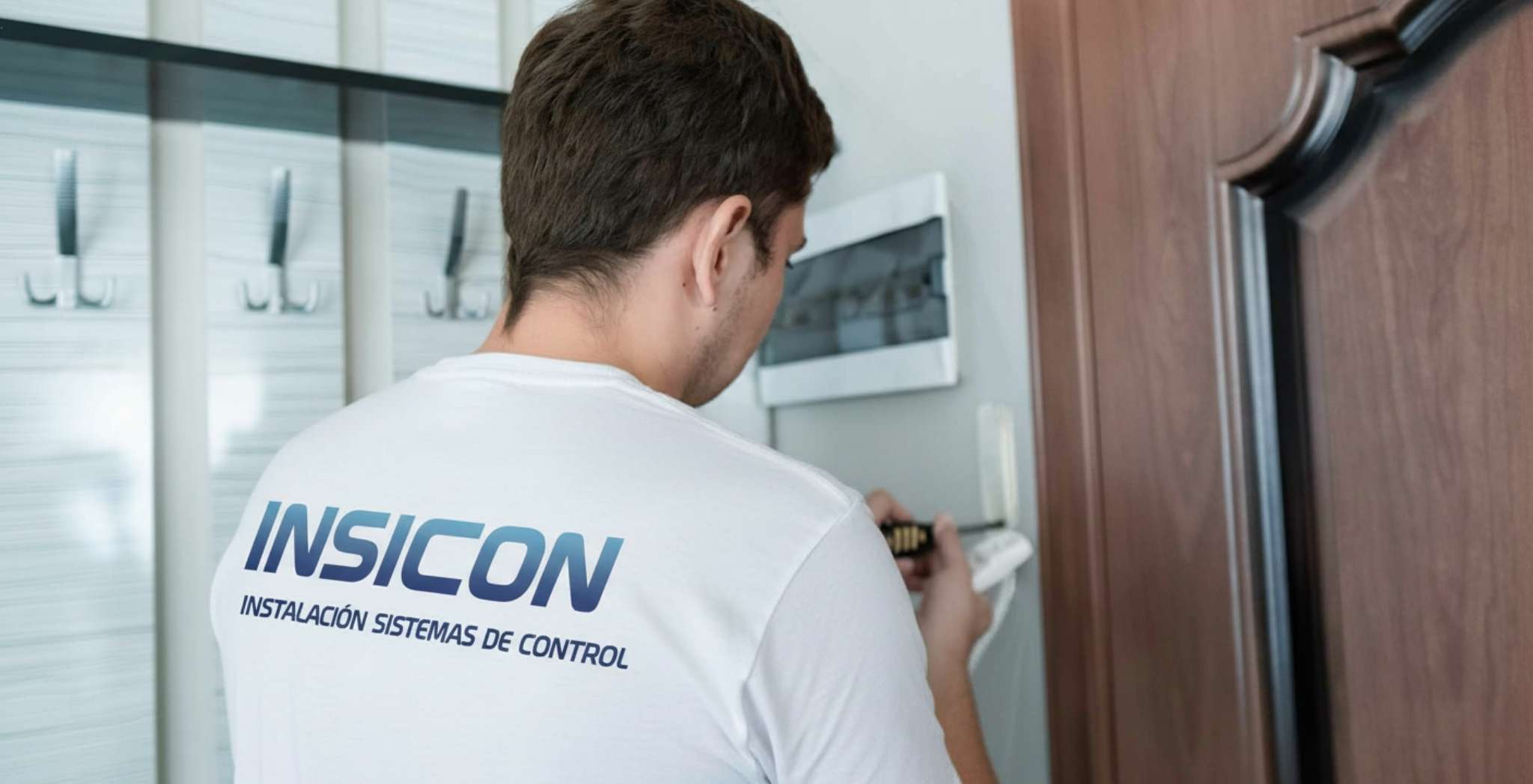 La imagen muestra un técnico realizando una operación de mantenimiento de un telefonillo